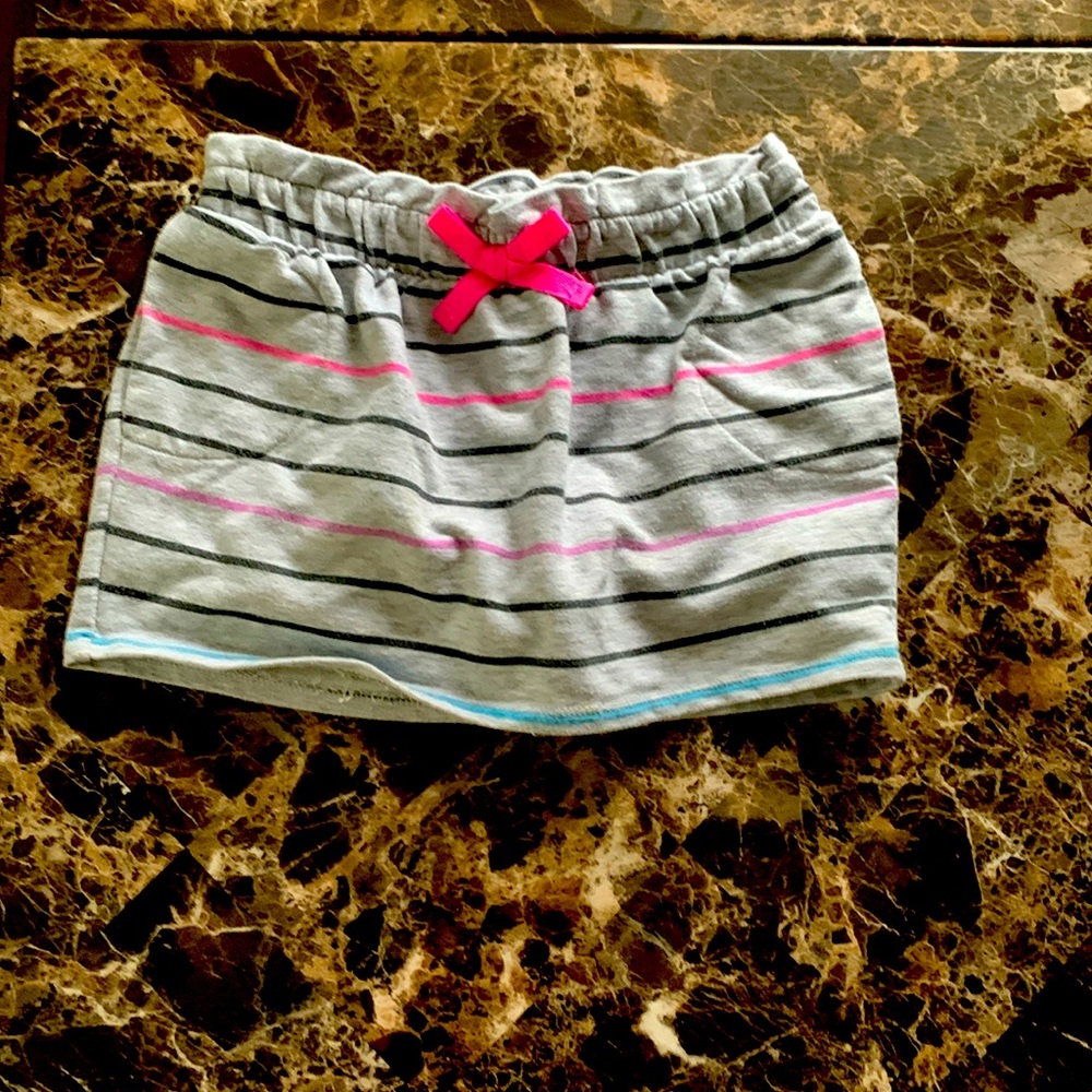 A gray skort with black pink, purple and blue stripes